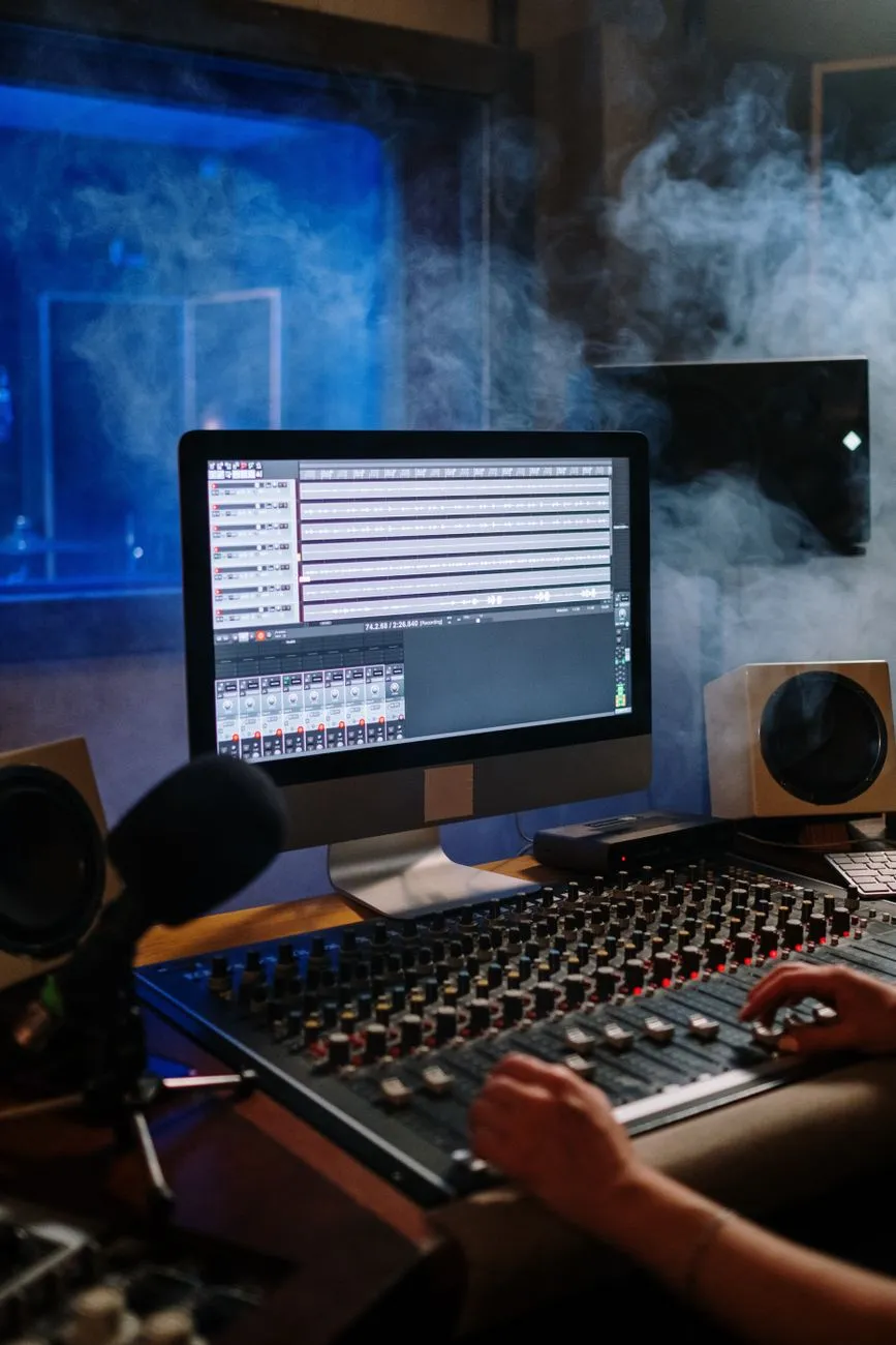 A modern music studio with audio mixer and computer screen displaying tracks