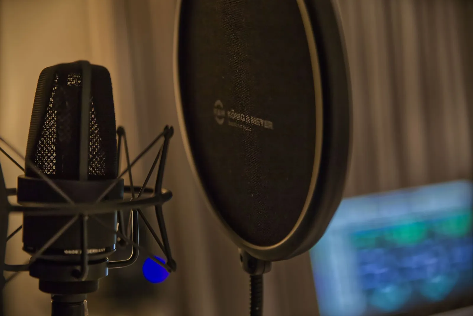 Close up of a studio microphone and pop filter in a recording environment